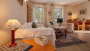 A room with a bed, a desk, a chair, a lamp, and a window with curtains. - Bel'Alp 16 Historical Residence Near Ski Lifts at Le Tour in Chamonix, Le Tour (Argentière), France (Le Tour (Argentière))
