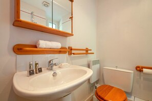 A bathroom with a white sink, wooden shelf, and a toilet. - Bel'Alp 16 Historical Residence Near Ski Lifts at Le Tour in Chamonix, Le Tour (Argentière), France (Le Tour (Argentière))