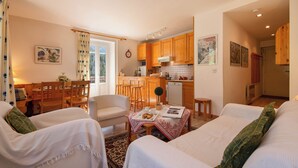 A cozy living room with a dining area, a kitchen, and a separate bedroom. - Bel'Alp 16 Historical Residence Near Ski Lifts at Le Tour in Chamonix, Le Tour (Argentière), France (Le Tour (Argentière))