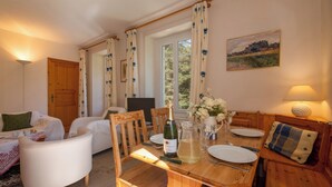 A dining area with a wooden table, chairs, a bottle of wine, and a pitcher of water. - Bel'Alp 16 Historical Residence Near Ski Lifts at Le Tour in Chamonix, Le Tour (Argentière), France (Le Tour (Argentière))