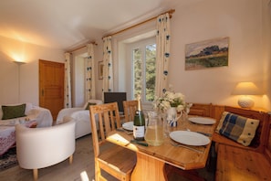 A dining area with a wooden table, chairs, a bottle of wine, and a pitcher of water. - Résidence Bel'Alp 16, Le Tour (Argentière), France (Le Tour (Argentière))