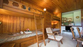 Un intérieur en bois avec un banc, des chaises, une échelle et un téléviseur.