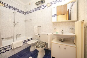 A bathroom with a bathtub, a toilet, and a sink. - Pool House in Lugano with Shared Garden, Lugano, Switzerland (Lugano)