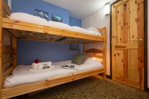 A bunk bed room with a wooden door and blue walls. - Grand Roc B9 260m from Slopes, Mountain View & Parking, Argentière (Chamonix), France (Argentière (Chamonix))