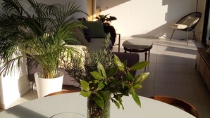 Una cocina moderna con una mesa blanca, una planta en maceta y un cuenco de limones.