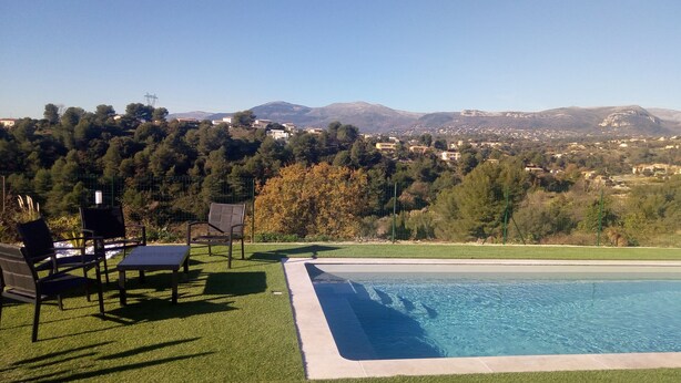 Una piscina con vistas a un pueblo y montañas al fondo.