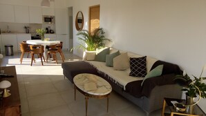 Una sala de estar moderna con sofá, mesa de centro y comedor con sillas y una mesa.