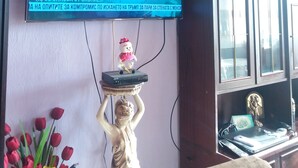 Un téléviseur fixé au mur diffusant un journal télévisé.