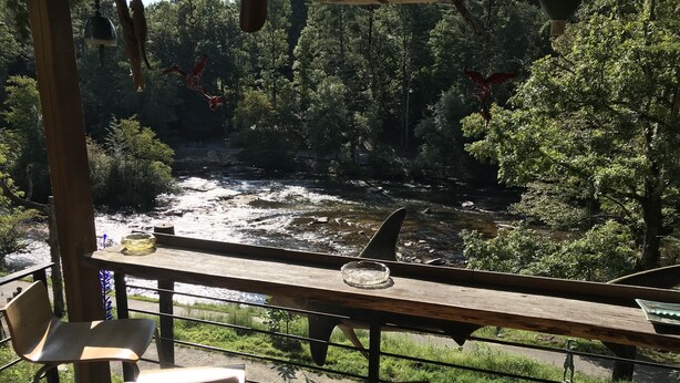 A wooden table with chairs overlooking a river, surrounded by greenery. - Blue Ridge Castaway Cabin on The Toccoa River (Blue Ridge)