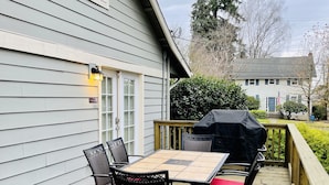 A deck with a table and chairs, a barbecue grill, and a view of a house in the background. - Great location for visiting the NW. Comfortable 5 bedroom home. (Portland)