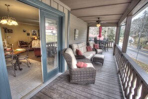 A covered porch with wicker furniture and a dining area.