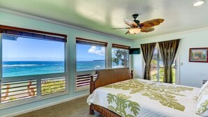 A bedroom with a large bed, a ceiling fan, and a view of the ocean. - Haena Beachfront With Stunning Panoramic Ocean Views TVNC # 5134  (Hanalei, Haena)