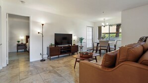 A living room with a TV, sofa, and dining area. -  DOWNTOWN PALM SPRINGS POOLSIDE LOWER  CONDO STEPS TO CASINO   (Palm Springs)