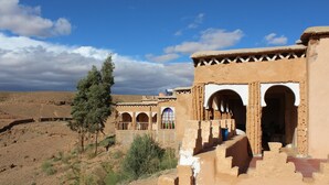 A traditional building with arched doorways and a courtyard. - Dar Timitar Eco lodge  (Kelâat M'Gouna)