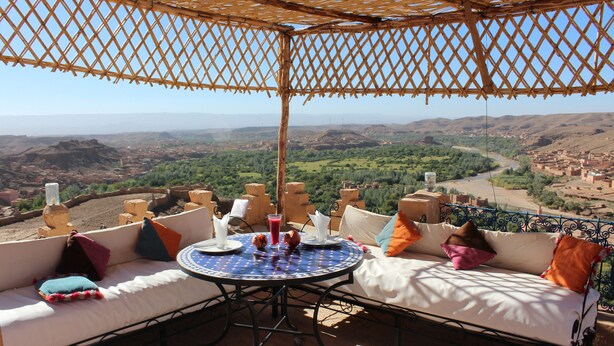 A terrace with a round table and two sofas, overlooking a valley. - Dar Timitar Eco lodge  (Kelâat M'Gouna)