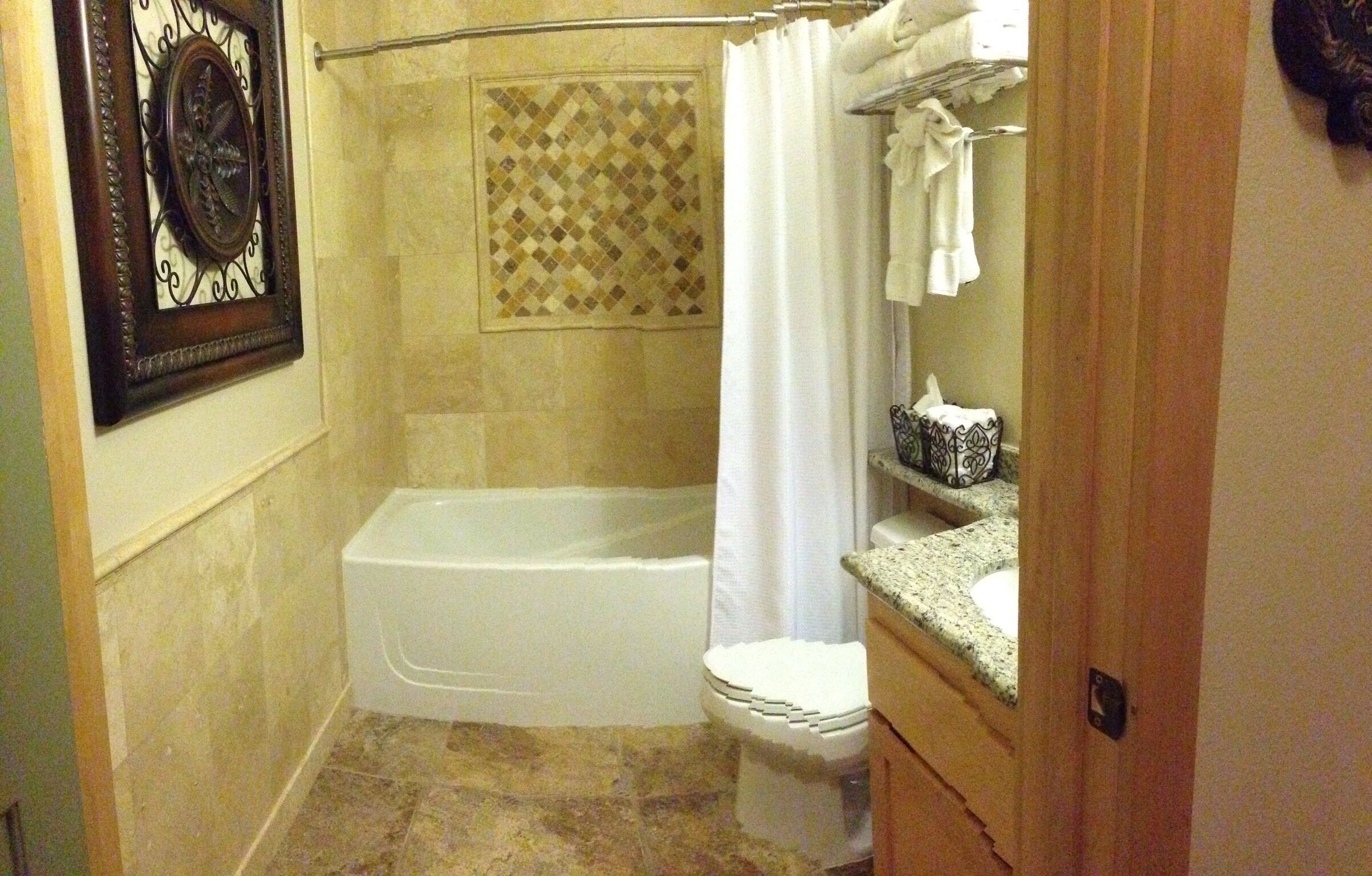 Ein Badezimmer mit Badewanne, Toilette und Duschvorhang.
