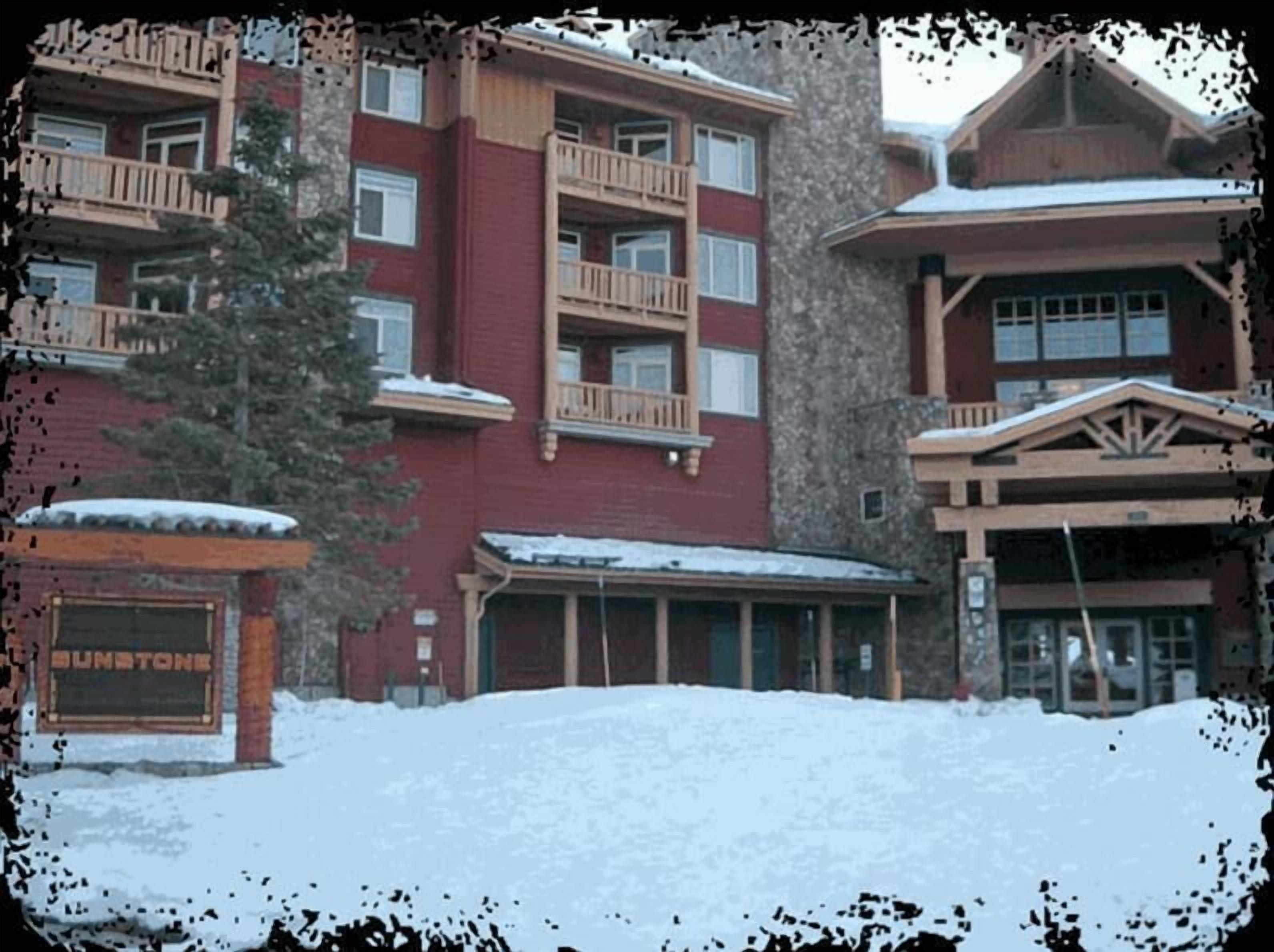 Un hôtel à plusieurs étages, doté d’une façade rouge et de balcons en bois.