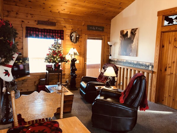 A cozy log cabin interior with a wooden ceiling, a Christmas tree, a fireplace, and a comfortable seating area. - MountainView Cutest Bear Cabin in Gatlinburg Cozy Close to Town Hot Tub Romantic (Gatlinburg)