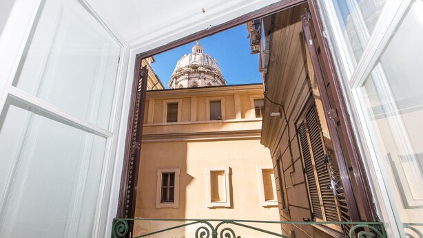 An architectural view of a building with a dome and a balcony with a wrought iron railing. - Rental In Rome Arenula Apartment (Rome)