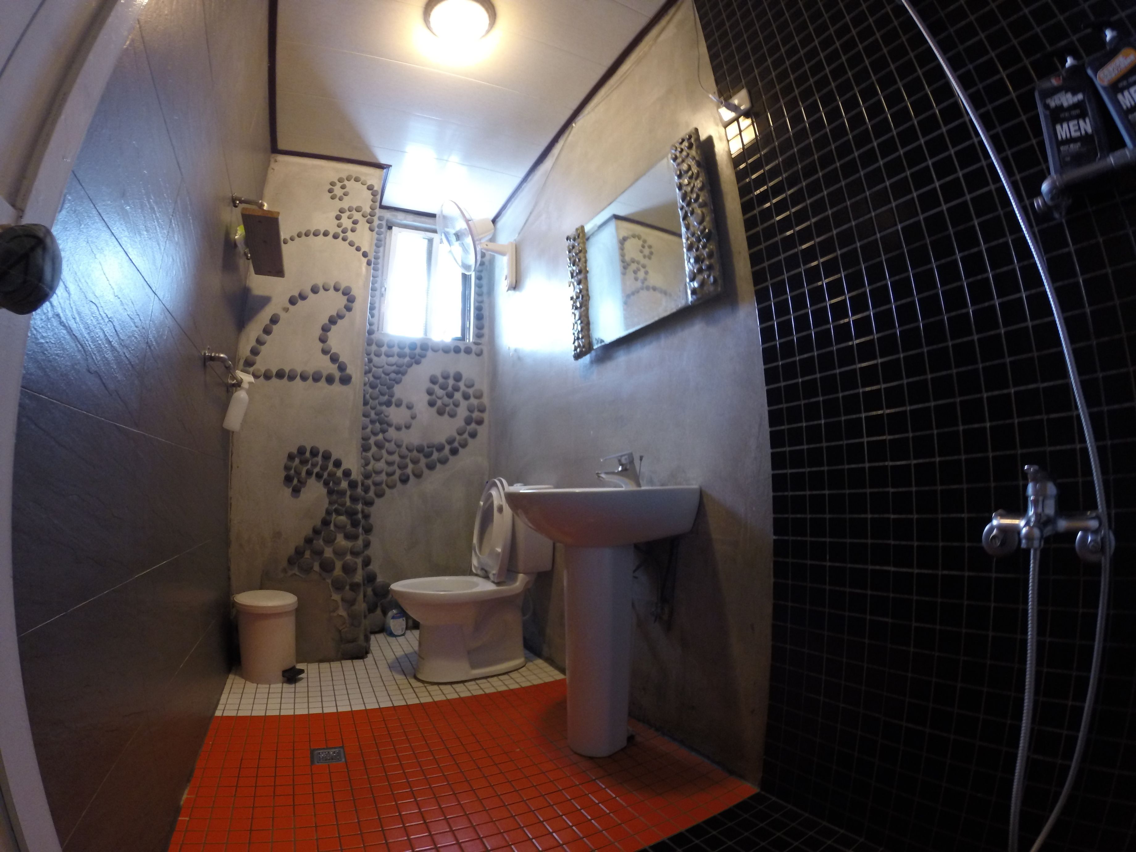 A compact bathroom with a toilet, sink, and shower area.
