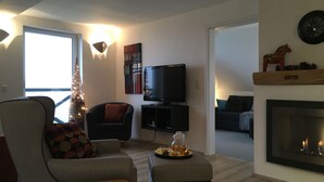 A modern living room with a TV, fireplace, and a Christmas tree. - Mountain idyll in the Steigerhaus Sauerland - DG Nord (Andreasberg)