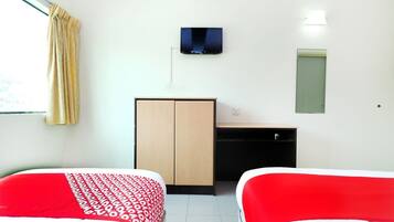 Habitación de hotel con dos camas, un armario, un escritorio, un televisor y una ventana con cortinas.