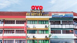 Un hotel llamado OYO Hotel con un letrero en varios idiomas, incluyendo inglés y chino.