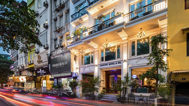 A hotel with multiple floors, outdoor seating, and balconies with plants. - Acoustic Hotel & Spa (Hanoi)