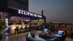 An outdoor bar area with a sign reading "Eclipse Sky Bar," featuring wicker furniture and a patterned floor. - Acoustic Hotel & Spa (Hanoi)