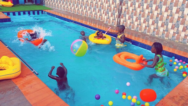 Ein Schwimmbecken mit Luftmatratzen und bunten Bällen.
