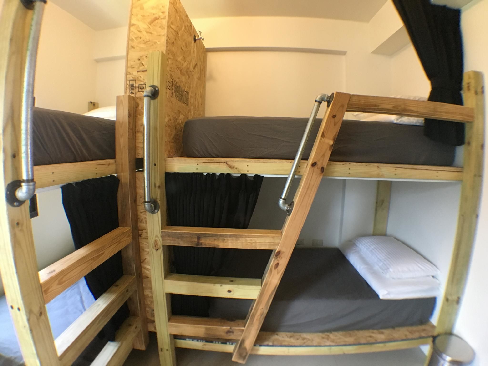 A bunk bed room with a wooden ladder and metal railings.
