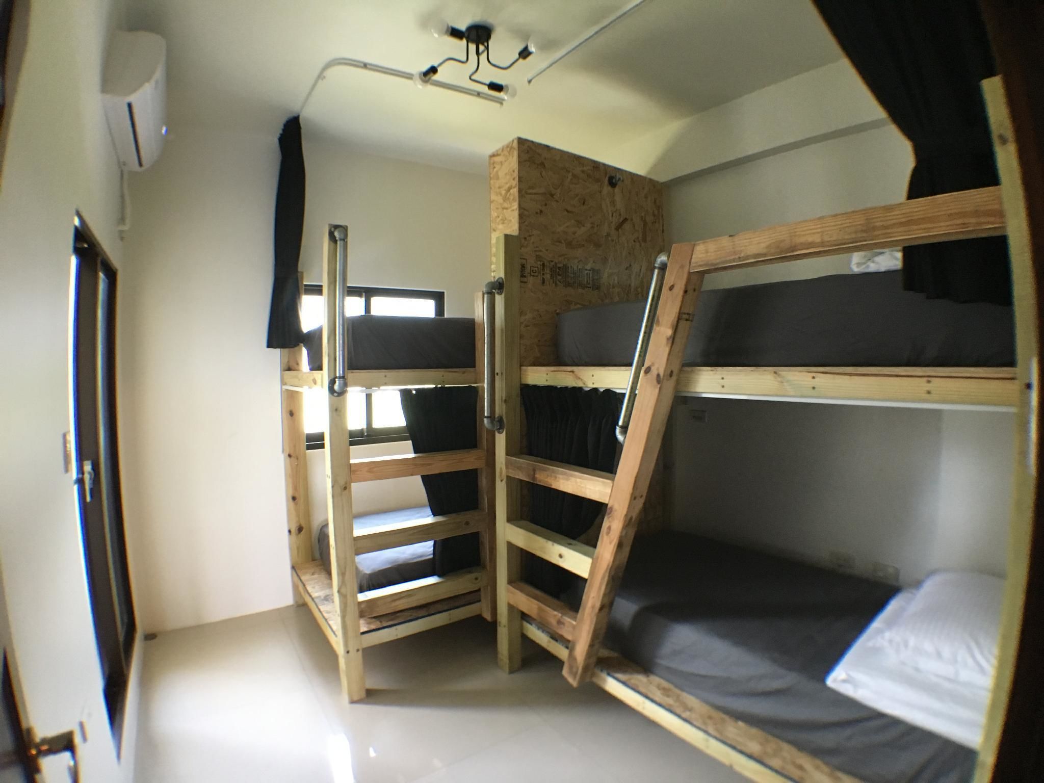 A bunk bed room with a wooden ladder and a window.