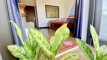 Una camera d'albergo con un letto, un tavolino, uno specchio e una finestra con tende.