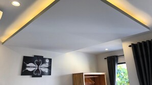Une chambre moderne dotée d’un éclairage encastré au plafond, d’une armoire en bois et d’un porte-manteau mural.
