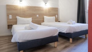 Two beds with wooden headboards, white bedding, and bedside lamps. - La Petite Pierre - ULVF Vacances (La Petite-Pierre)