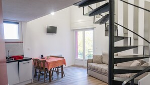 A modern kitchen with a dining area, a staircase, and a sofa. - La Petite Pierre - ULVF Vacances (La Petite-Pierre)