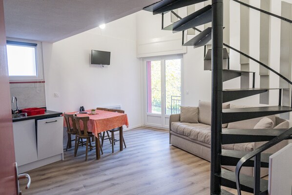 A modern kitchen with a dining area, a staircase, and a sofa. - La Petite Pierre - ULVF Vacances (La Petite-Pierre)