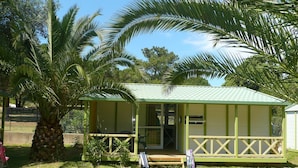 A small, single-story building with a green roof and a porch. - Camping U Libecciu  - Vacances ULVF (Calvi)