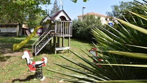 A playground with a slide and a small house structure. - Camping U Libecciu  - Vacances ULVF (Calvi)