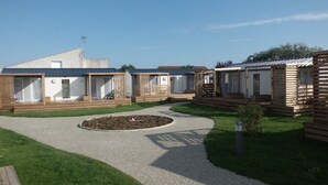 Una hilera de casas móviles con terrazas de madera y un sendero de grava que atraviesa el centro.