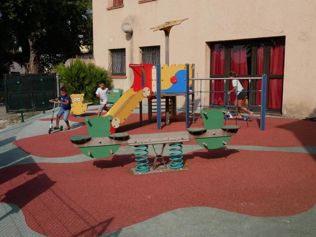 Ein Spielplatz mit Rutsche und Schaukeln.