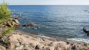 A rocky shoreline with clear blue water and a distant horizon. - Les Residences du Colombier - ULVF (Fréjus)