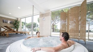 A hot tub in a modern indoor setting with a view of the outdoors. - Les Residences du Colombier - ULVF (Fréjus)