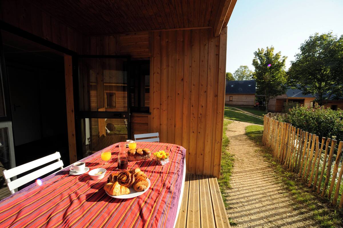 Una cabaña de madera con una mesa lista para el desayuno.