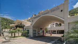 Een gebouw ingang met een bord waarop 'BOMBINHAS SUMMER BEACH' staat.