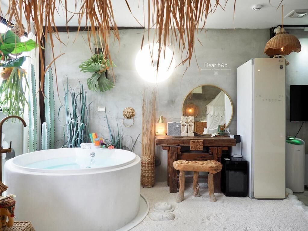 Un baño con una bañera grande, un tocador de madera, un espejo y un refrigerador.