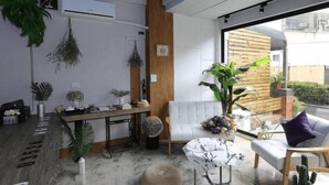 A modern interior with a reception desk, seating area, and large windows. - Fas Glass House B&B (Xincheng)