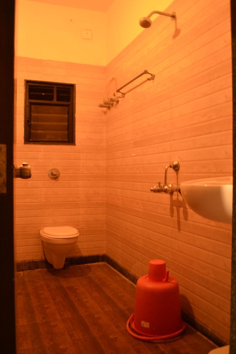Un baño pequeño y estrecho con inodoro, lavamanos y ducha.