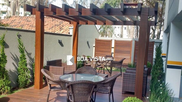 Un espace extérieur aménagé en terrasse, avec des meubles en osier et une structure en forme de pergola.