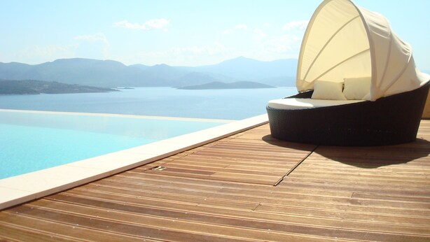 A wooden deck with a lounge chair and a canopy, overlooking a clear blue pool and distant mountains. - Modern, Family Friendly & Peaceful Villa with 15m long Infinite Private Pool & J (Theologos, Malesina)